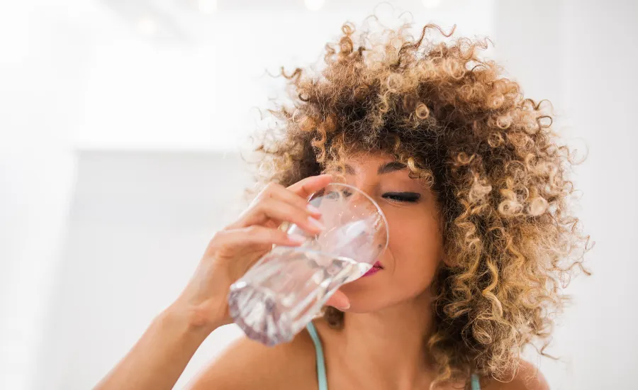 A woman drinking a glass of water