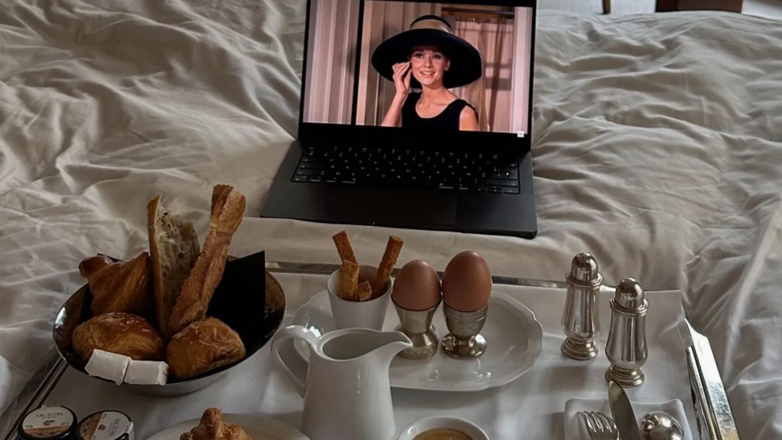 bed hotel in paris with breakfast and laptop playing breakfast at tiffany's
