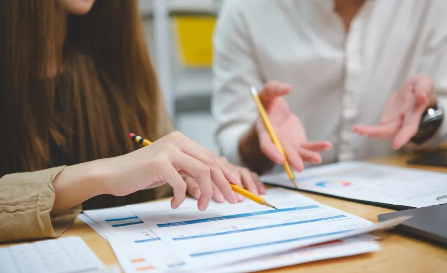 Professional woman reviewing documents at her desk preparing for mid-year performance review