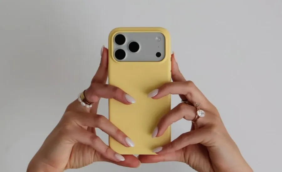 two woman hands holding an iphone 17 with yellow case