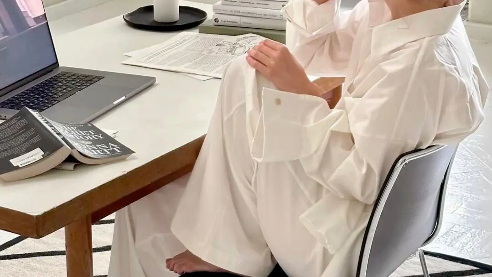 woman sitting in desk with her laptop and an open book