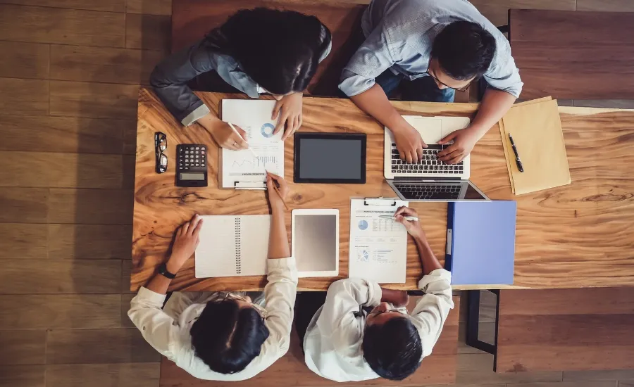 view of an office meeting desk with four colleagues working