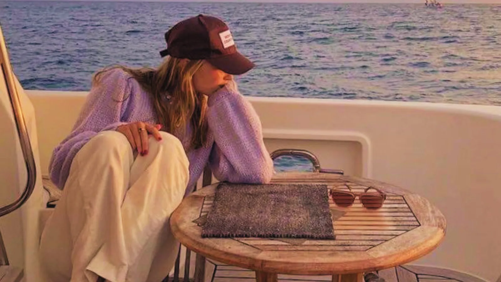 woman on a yacht in the sea sitting in table and gazing